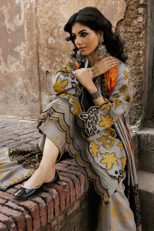 Woman in a patterned outfit sitting on a stone wall.