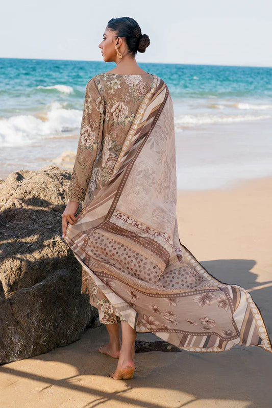 Woman in a patterned dress standing on a beach with ocean waves in the background