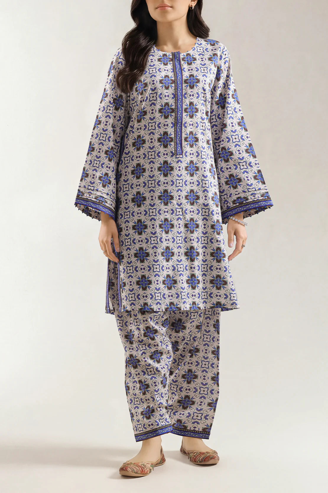 Woman wearing a blue and white patterned kurta with pants on a white background