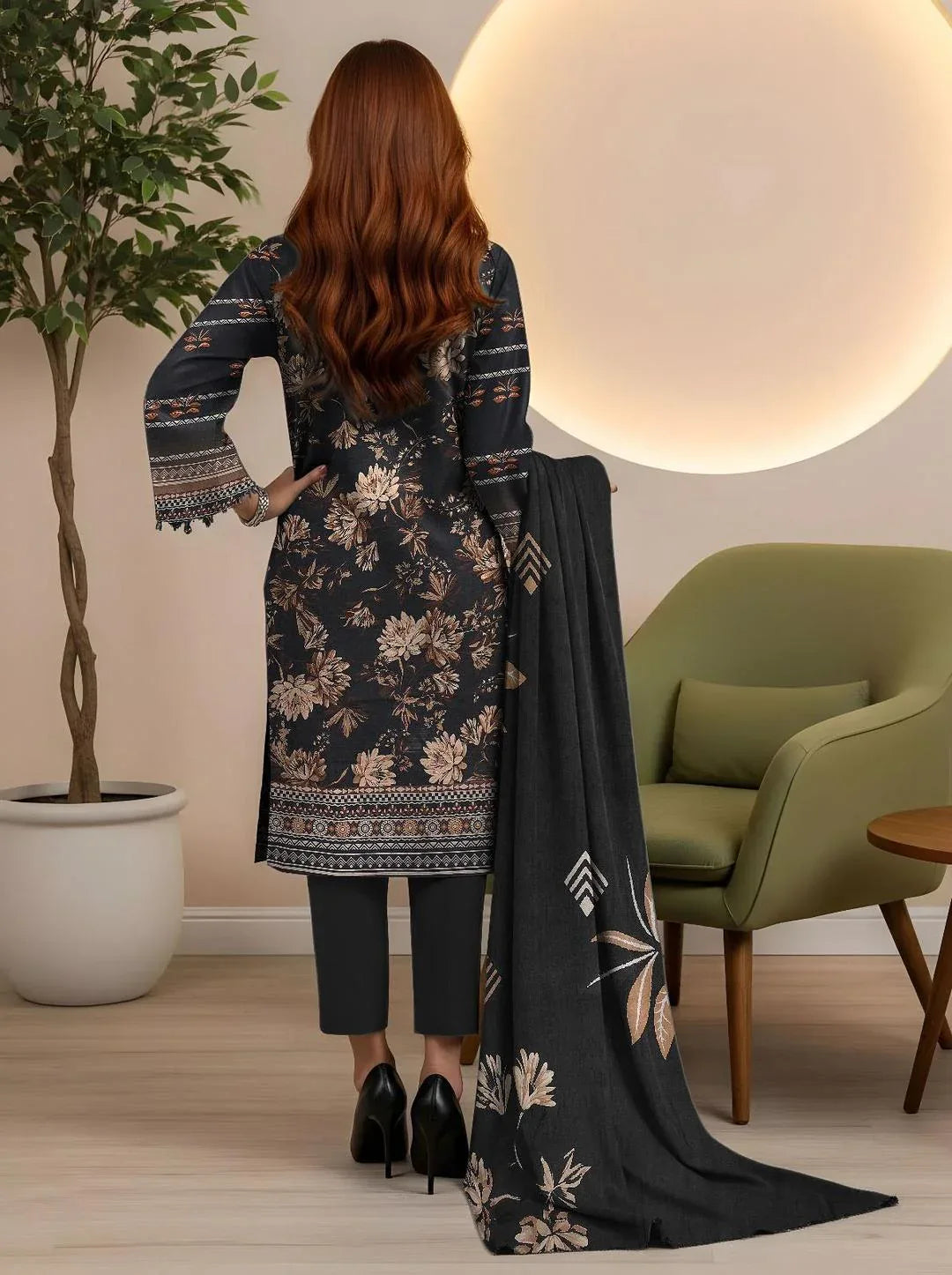 Woman in a floral dress with a matching scarf in a room with a green chair and plant.