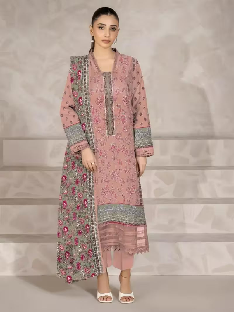 Woman wearing a pink and gray embroidered traditional outfit on a neutral background