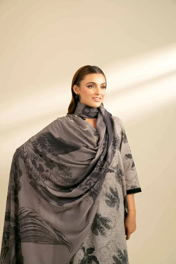 Woman wearing a gray floral patterned scarf on a plain background