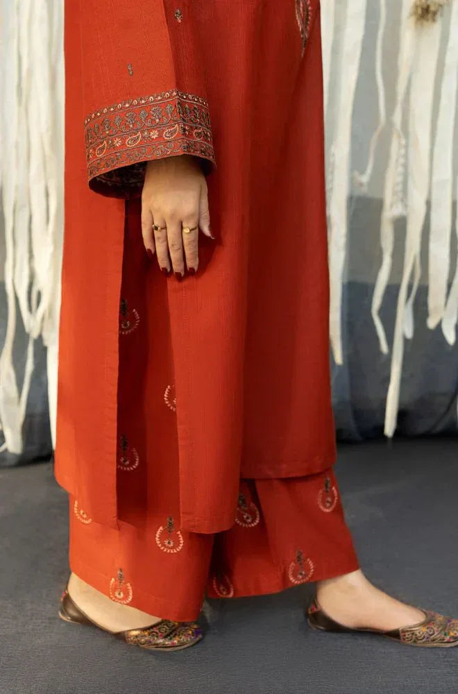 Red traditional outfit with intricate patterns on a neutral background