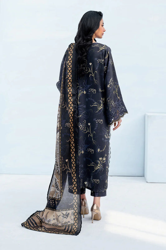 Woman wearing a dark blue embroidered outfit with a sheer dupatta against a white background