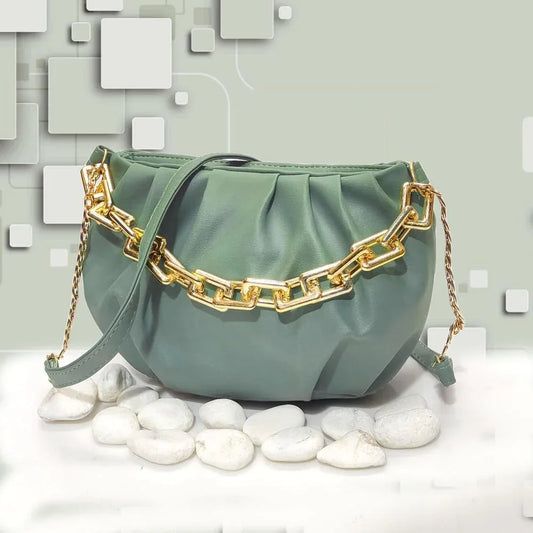 Green handbag with gold chain detail on a light gray background