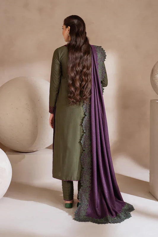 Woman wearing a green outfit with a purple dupatta in a minimalistic setting