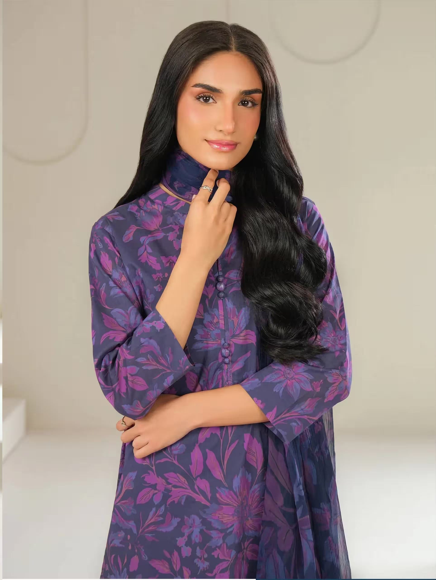 Woman wearing a purple floral dress against a neutral background