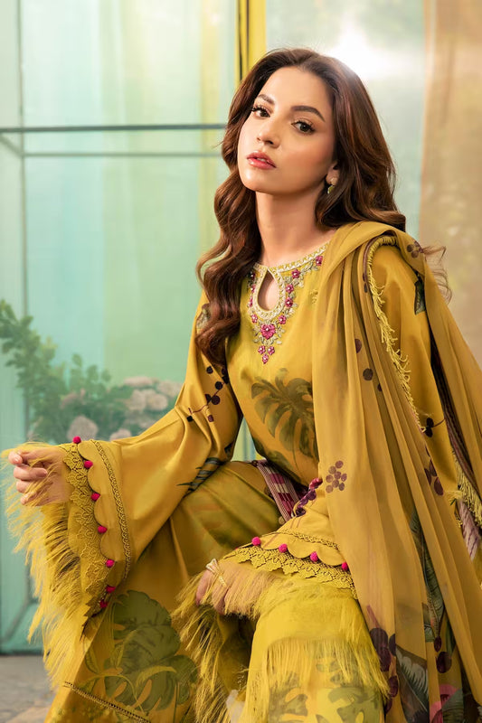 Woman in a yellow embroidered traditional outfit sitting indoors.