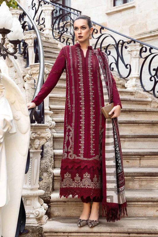 Woman in a burgundy traditional outfit with intricate patterns standing on a decorative staircase.
