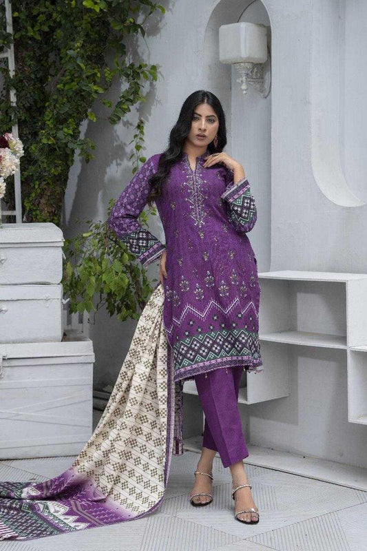 Woman wearing a purple embroidered traditional outfit in an indoor setting with white walls and greenery.
