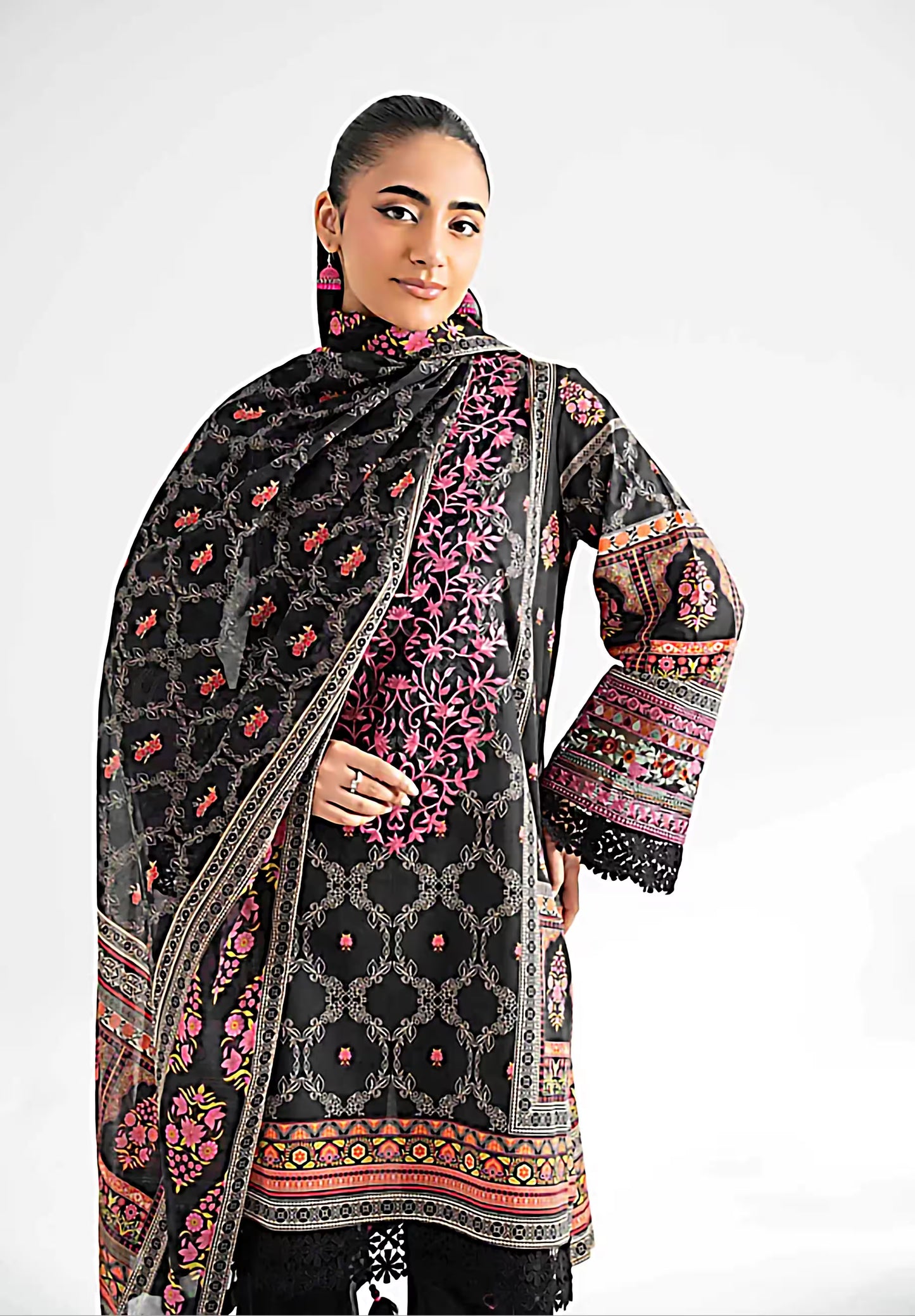 Woman wearing a black embroidered traditional outfit with a white background