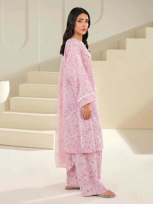 Woman in a pink floral outfit standing in a minimalistic setting with white stairs.
