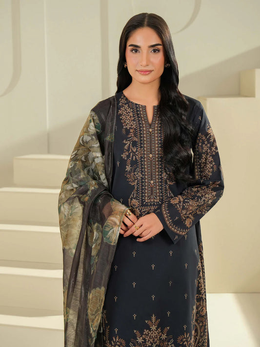 Woman wearing a dark blue embroidered outfit with a patterned shawl in an indoor setting.