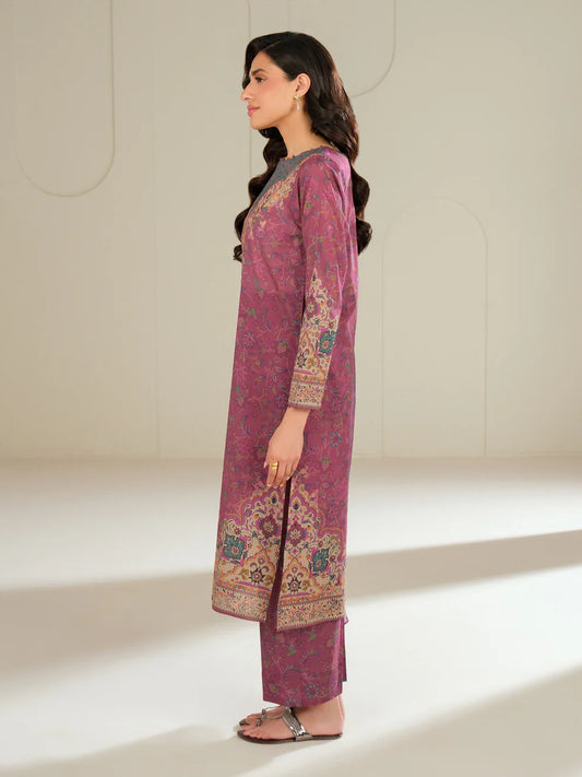 Woman wearing a pink traditional outfit with intricate patterns in a minimalistic setting