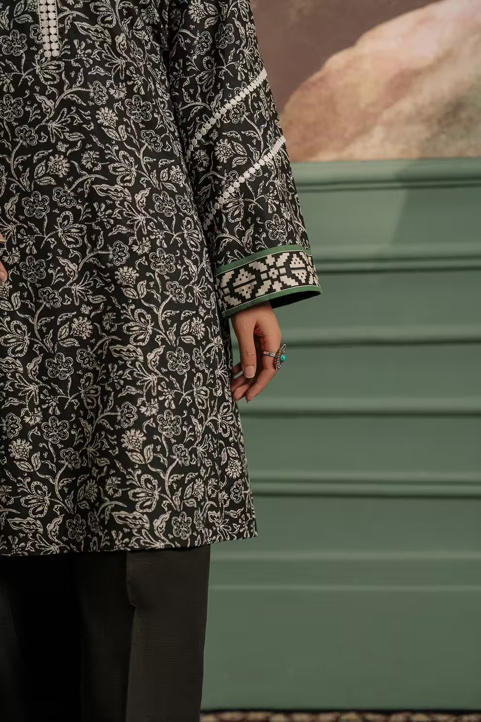 Person wearing a patterned coat with a green background