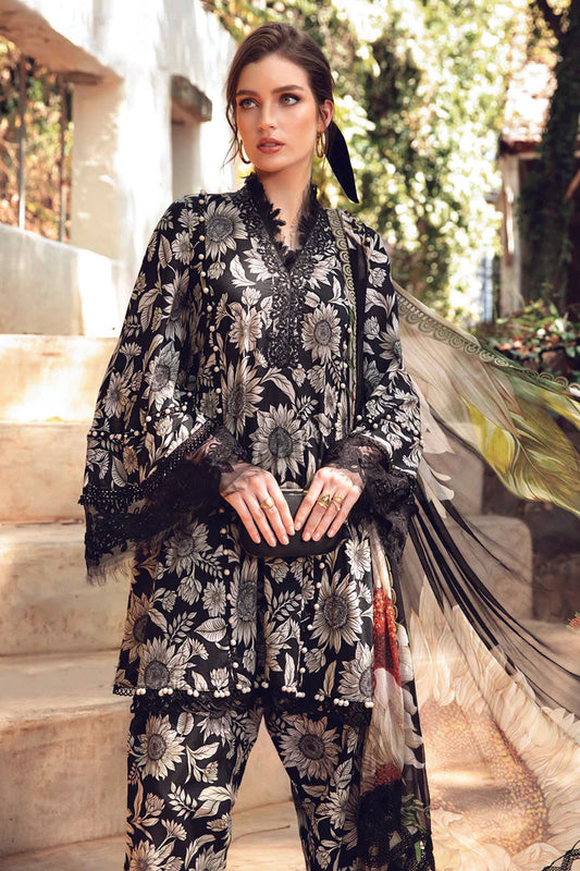 Woman wearing a black and white floral embroidered outfit with a dupatta in an outdoor setting.