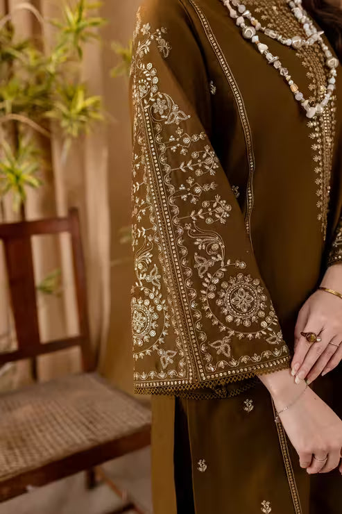 Brown traditional outfit with intricate white embroidery, held by a person.