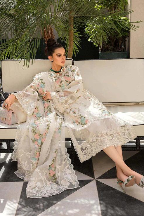 Woman in a floral dress sitting on a bench with greenery in the background