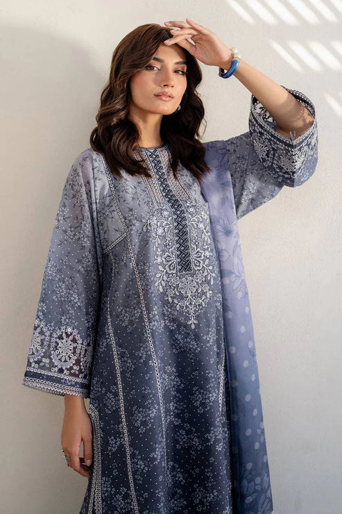 Woman wearing a blue embroidered dress against a plain background