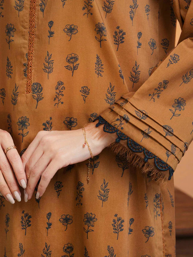 Close-up of a person wearing a brown garment with floral patterns, focusing on the fabric and hand.