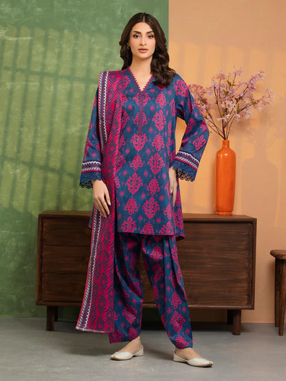 Woman wearing a blue and pink traditional outfit with a vase and plant in the background