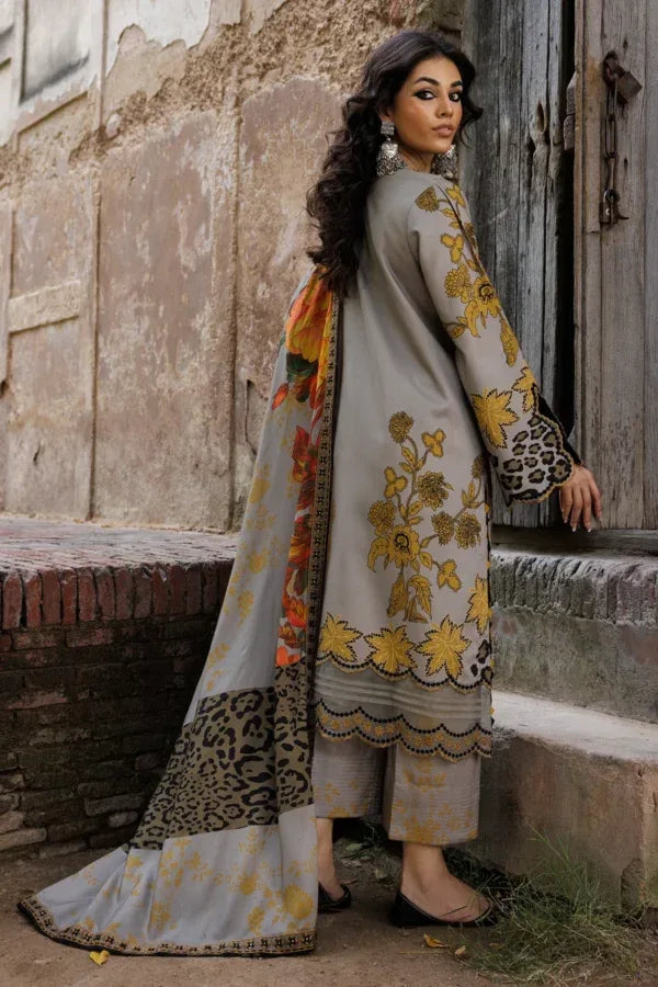 Woman in a floral and leopard print outfit standing against a rustic wall.