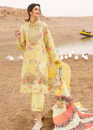 Woman in a yellow floral dress standing by a desert lake with boats in the background