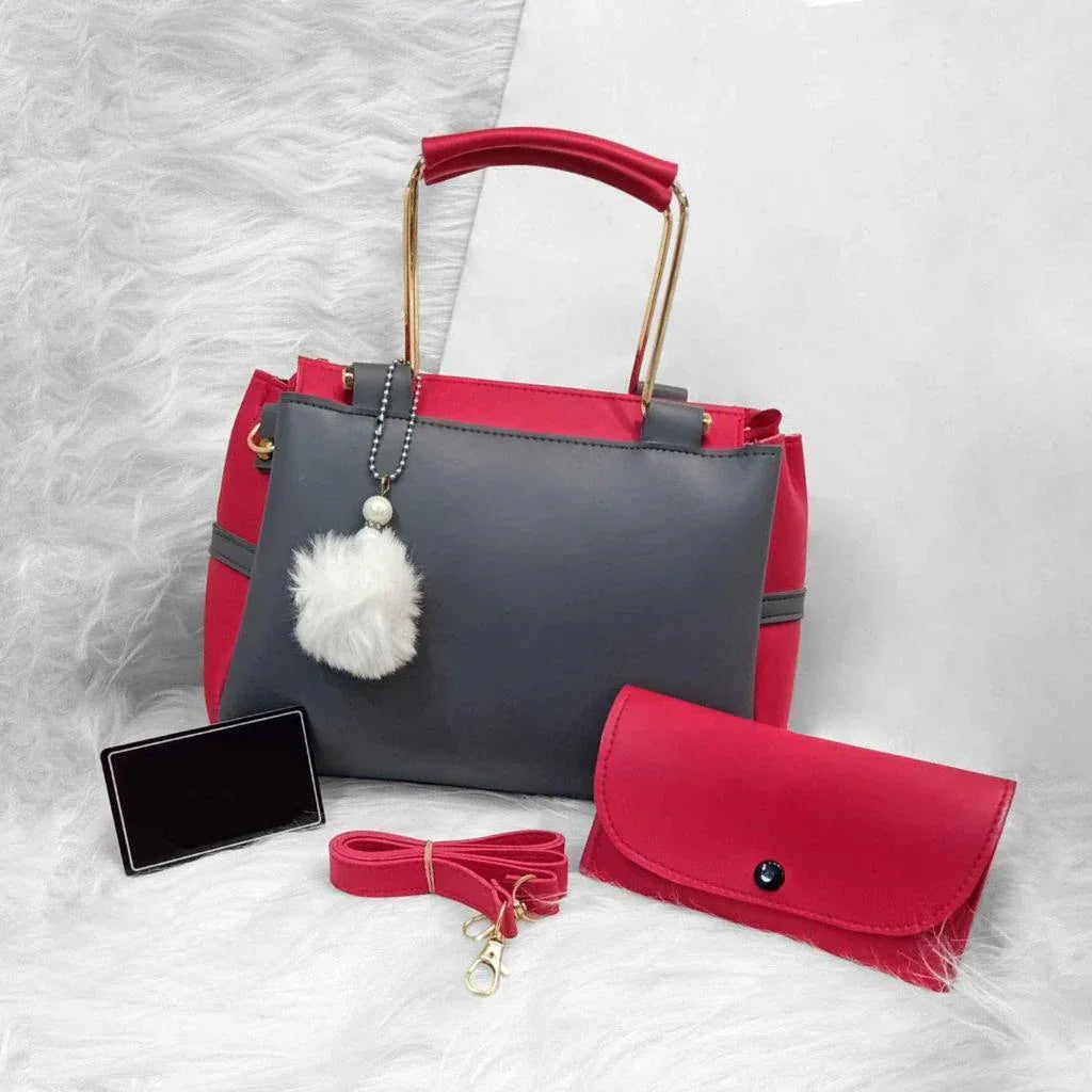 Red and gray handbag with a matching wallet and strap on a textured white surface
