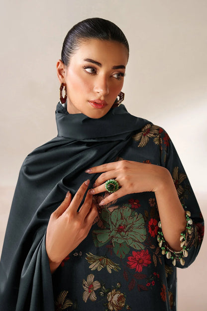 Woman wearing a dark green floral dress with a plain background