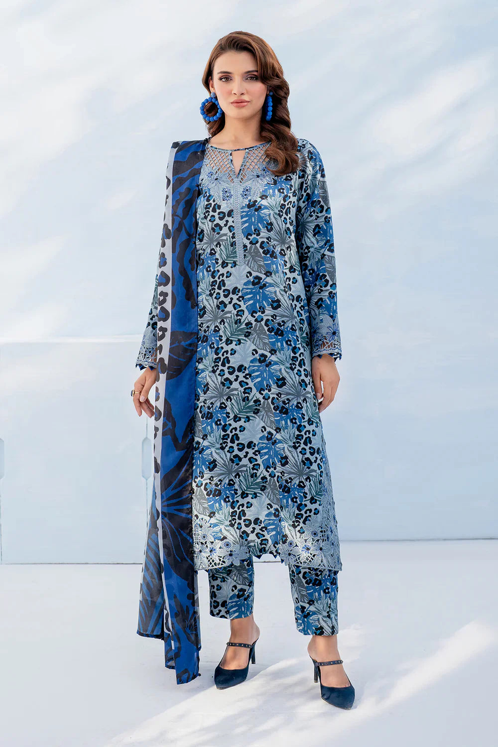 Woman wearing a blue floral outfit with a matching jacket against a light background