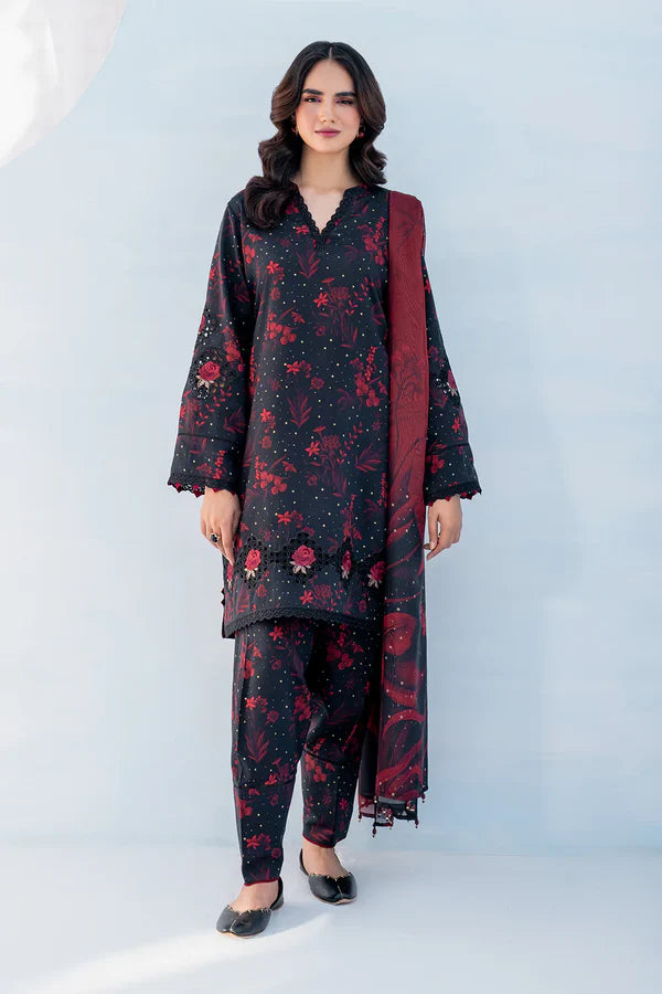 Woman wearing a black floral outfit with a red dupatta on a light gray background