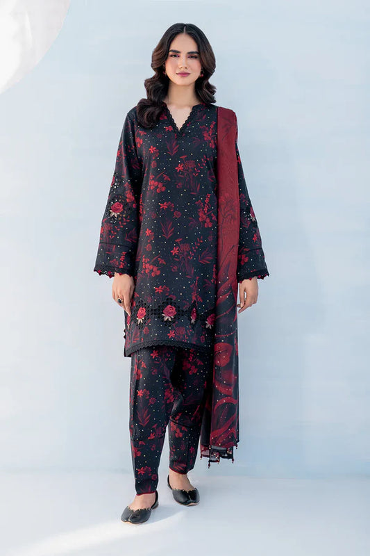 Woman wearing a black floral outfit with a red dupatta on a light gray background