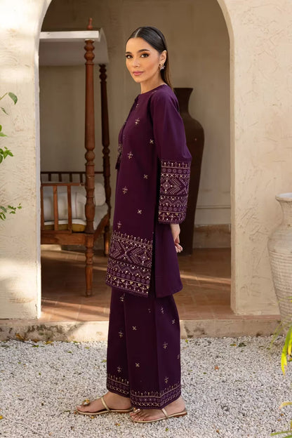 Woman in a purple traditional outfit standing in an outdoor setting.