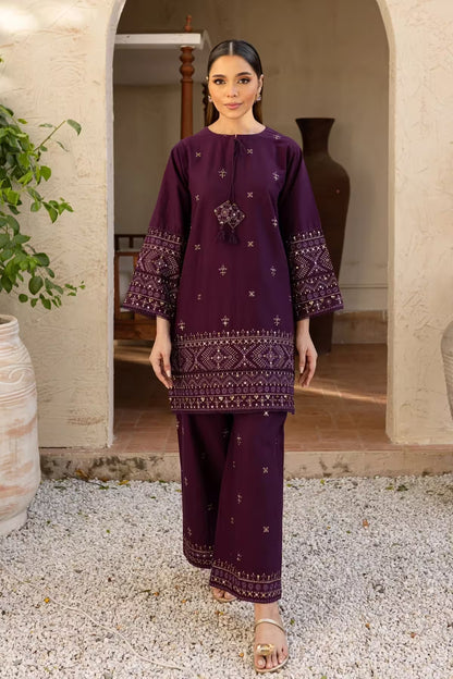 Woman wearing a purple embroidered outfit standing in an outdoor setting.