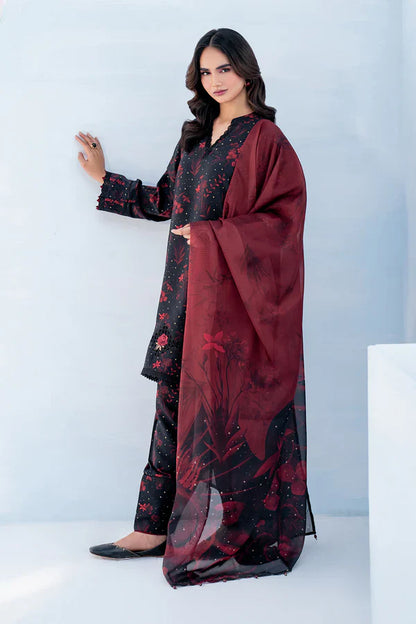 Woman wearing a dark floral dress with a red dupatta against a white background
