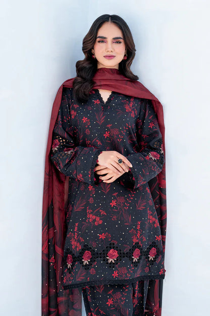 Woman wearing a black floral dress with a red dupatta against a white background