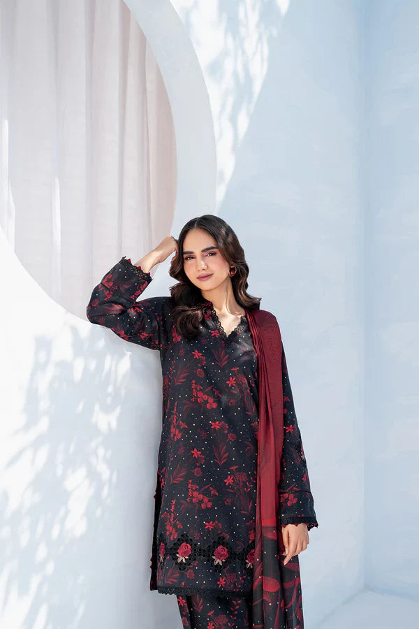 Woman wearing a black floral dress with a red dupatta against a white background