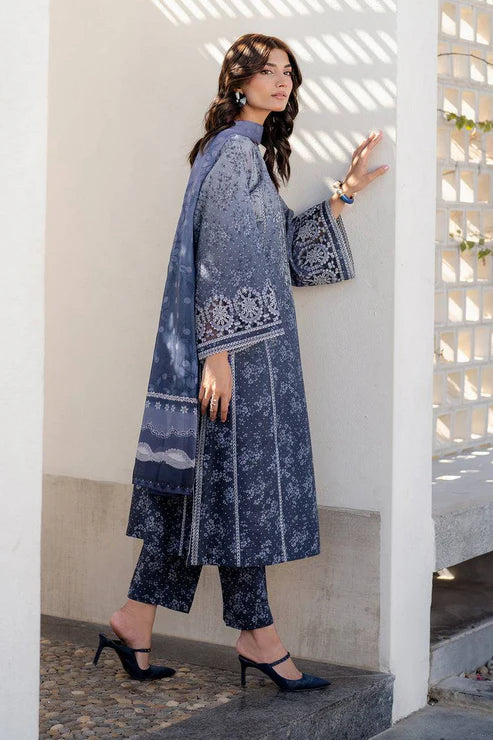 Woman in a blue patterned outfit standing on stone steps.