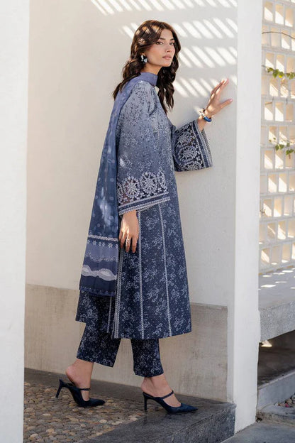 Woman in a blue patterned outfit standing on stone steps.