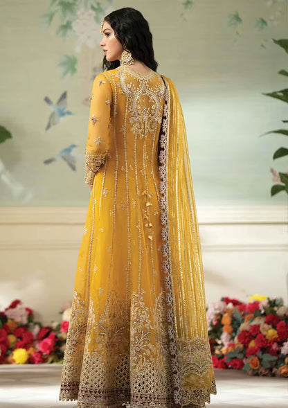Woman wearing a yellow embroidered traditional outfit with a floral background