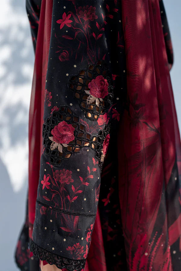Close-up of a garment with red floral embroidery on a dark background
