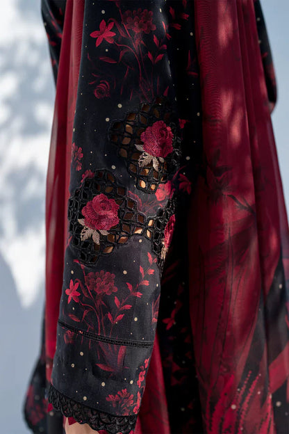 Close-up of a garment with red floral embroidery on a dark background