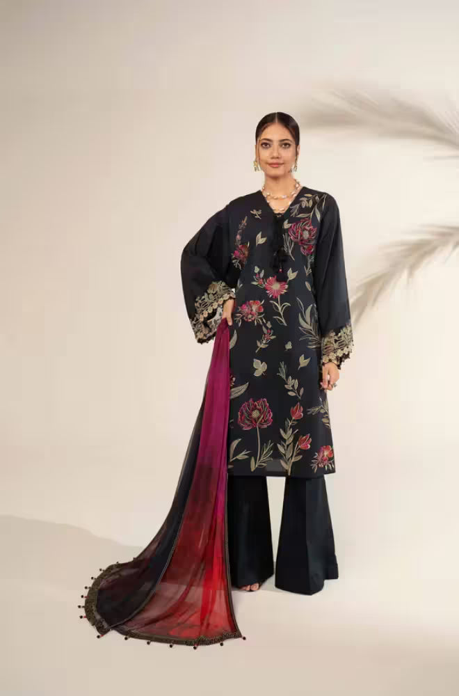 Woman wearing a black floral embroidered outfit with a red dupatta on a white background