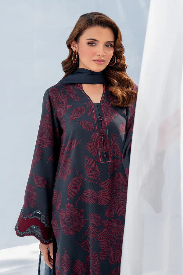 Woman wearing a dark red and black patterned dress with a plain background