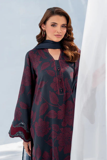 Woman wearing a dark red and black patterned dress with a plain background