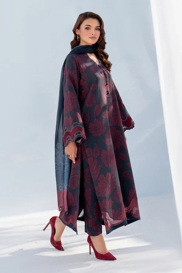 Woman wearing a long, patterned dress with red shoes on a light background