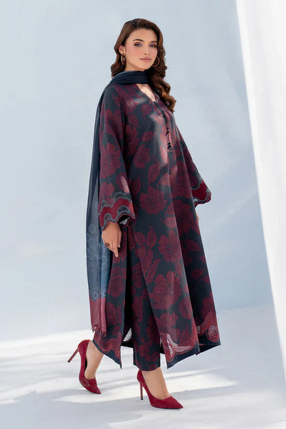 Woman wearing a long, patterned dress with red shoes on a light background