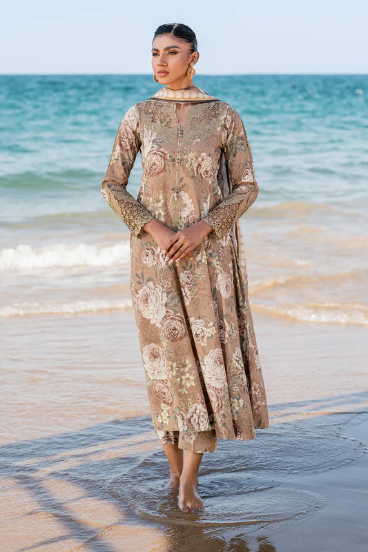 Woman in a floral dress standing on a beach with ocean in the background