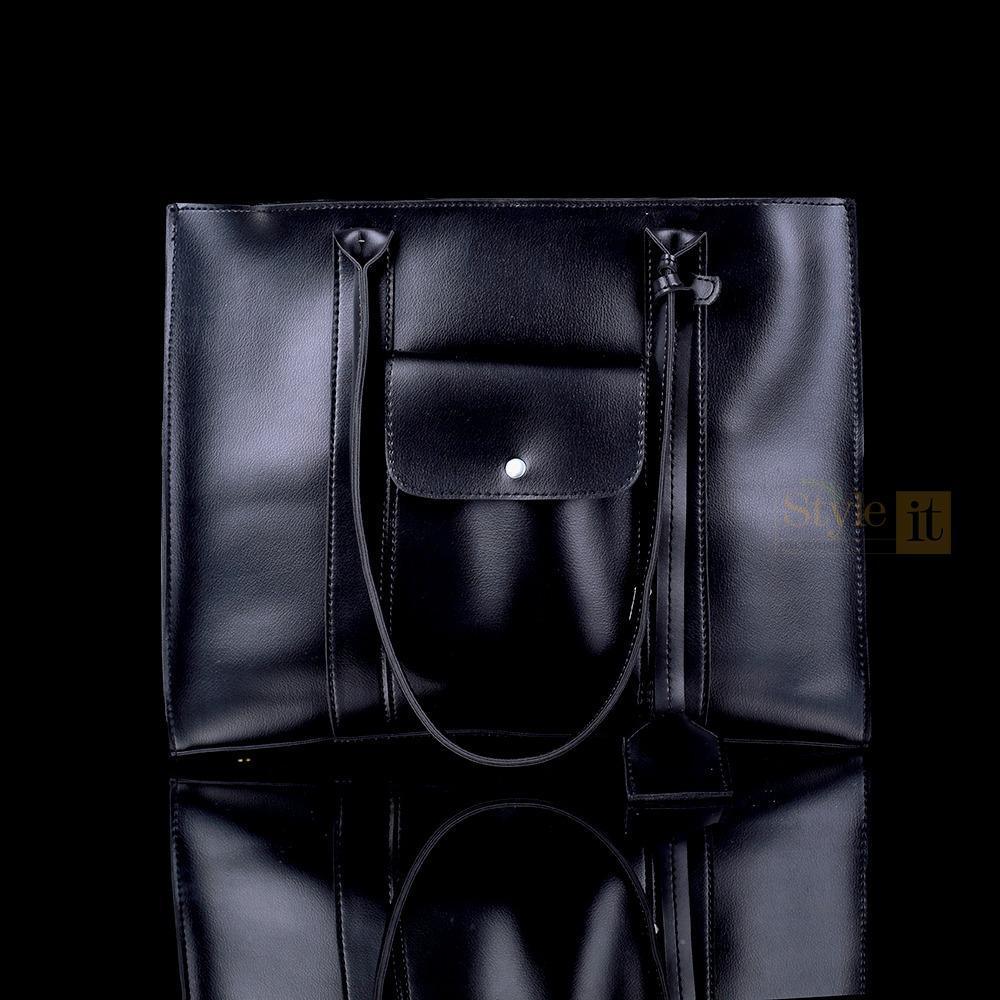 Black leather tote bag with a visible brand logo on a black background