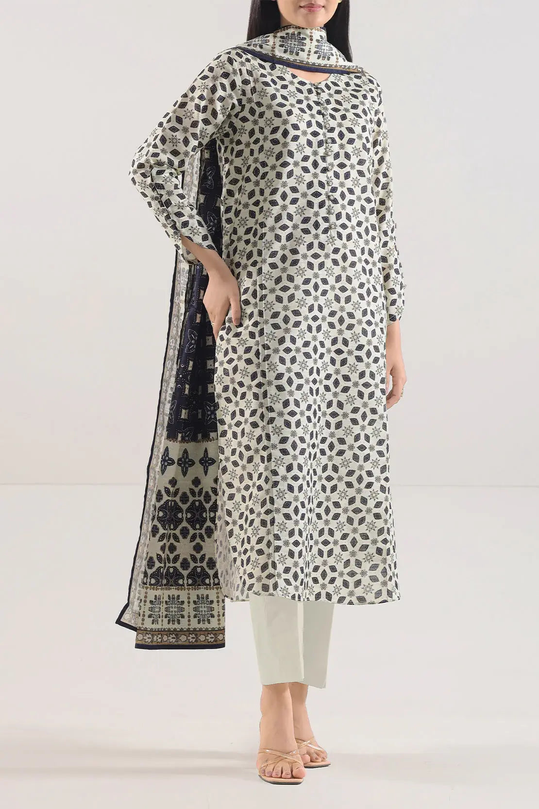 Woman wearing a patterned kurta with a matching dupatta on a white background